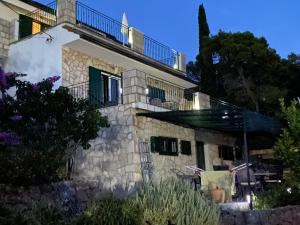 a stone house with a balcony on top of it at Apartments Vila Vino in Sveta Nedelja