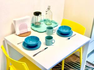 a table with plates and cups and a bottle on it at Charming City Apartment - by Nahuen Suites in Graz