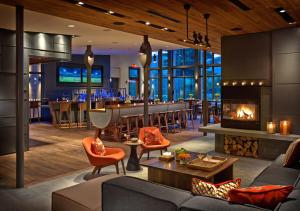 a living room with a fireplace and a bar at Topnotch Resort in Stowe