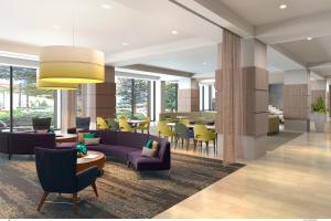 una hall con divano viola, tavoli e sedie di Crowne Plaza Atlanta Midtown, an IHG Hotel ad Atlanta