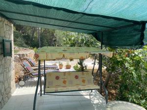 a table and chairs under a green umbrella on a patio at Apartments Vila Vino in Sveta Nedelja