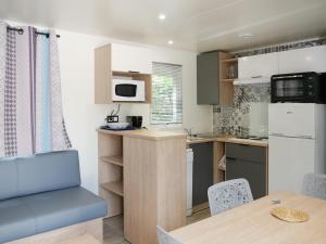 una cucina e una sala da pranzo con tavolo e sedie di Les Mobil-homes By Le Marintan a Saint-Michel-de-Maurienne