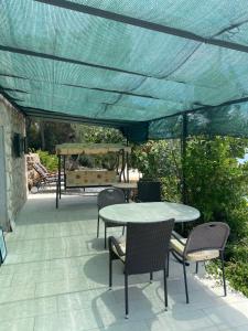 a patio with a table and chairs under a blue canopy at Apartments Vila Vino in Sveta Nedelja