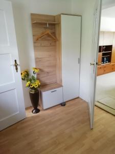 a room with a door and a vase with flowers at Kleines Haus mit Geschichte in Neukirchen