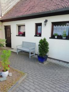 a blue bench sitting outside of a white house at Kleines Haus mit Geschichte in Neukirchen