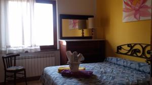 a bedroom with a bed and a chair and a window at Agriturismo l'Oasi in Foligno