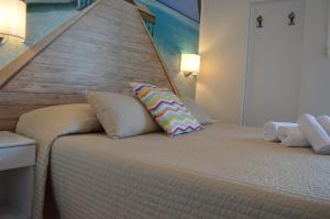 1 dormitorio con 1 cama grande y cabecero de madera en Hotel Merano, en Grado