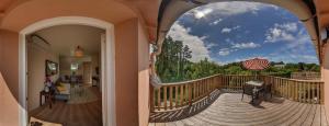 a balcony with a view of a deck with an umbrella at Gîtes de La Ferme De Kereven in Bénodet