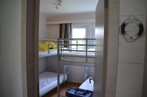 um pequeno quarto com beliches e uma janela em De Haan - Dahlia 007 em De Haan