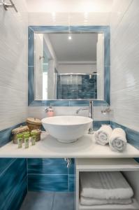 a bathroom with a sink and a mirror and towels at Anatoli Hotel in Naxos Chora