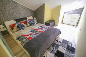 een slaapkamer met een bed met een quilt bij Centrum Lux 2 Apartmanok in Kaposvár