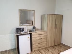 La cuisine est équipée d'un réfrigérateur et d'une armoire en bois. dans l'établissement atoom studio, à Jerash
