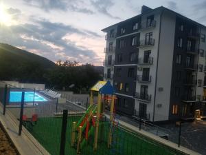 a playground in front of a building with a pool at Апартаменти Віланж in Polyana