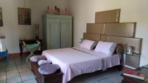 バッティパーリアにあるVilla le tre Dame B&Bのベッドルーム1室(大型ベッド1台、紫色の枕付)