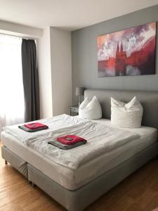 a bedroom with a large bed with red towels on it at City Apartment am Dom in Cologne