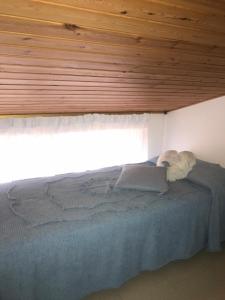 ポッリナにあるMansarda Stella sul Mareの木製の天井の客室のベッド1台分です。
