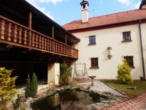 a house with a pond in front of it at Zámeček Zdíky - Zámecký apartmán in Bujanov
