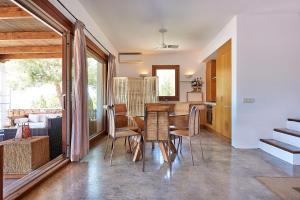 a kitchen and dining room with a table and chairs at Villa Sa Codolar in Cala Tarida