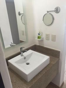 La salle de bains est pourvue d'un lavabo blanc et d'un miroir. dans l'établissement Zenharmony Suites, à Puerto Vallarta