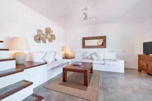 a living room with a white couch and a table at Villa Sa Codolar in Cala Tarida