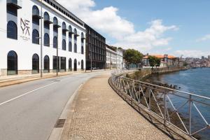an empty street next to a river with buildings at NEYA Porto Hotel in Porto