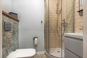 ein Bad mit einer Dusche, einem WC und einem Waschbecken in der Unterkunft MECHELINKI APARTAMENT in Mechelinki