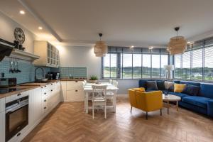 a kitchen and living room with a blue couch at MECHELINKI APARTAMENT in Mechelinki