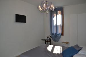 una camera con letto e lampadario a braccio di Ca' Bacio della Luna a Venezia