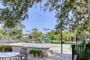 una pista de tenis con mesas y sillas en una terraza de madera en Courtside 1412, en Kiawah Island