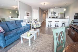 a living room with a blue couch and a kitchen at Beach Room 214 in Traverse City