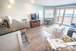 a kitchen and living room with a couch and a tv at Beach Room 214 in Traverse City