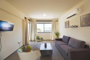 Leucolla Hill & Sea في بروتاراس: غرفة معيشة مع أريكة وطاولة