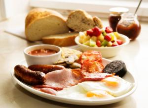 um prato de comida de pequeno-almoço com ovos, salsicha e pão em Glendower em Torquay