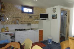 a kitchen with a sink and a tv on the wall at Casetta Costa Turchina in Pollina