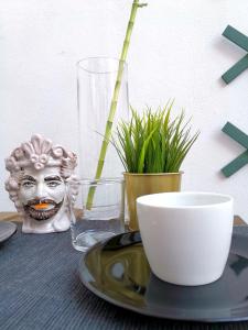 a table with a plate and a bowl and plants at Casa Pirri in Palermo