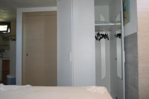 a room with a bed and a closet with shoes at Casetta Costa Turchina in Pollina