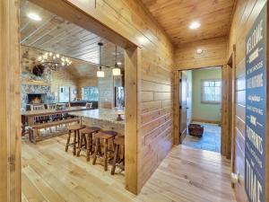 a kitchen with wooden walls and a bar with stools at Wee-Kin-Da-Wa in Boyne Falls