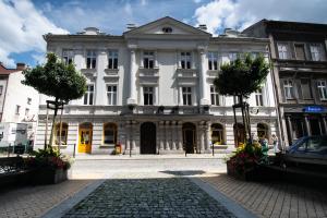 a large white building with trees in front of it at Apartament INSIDE - centrum Bielsko-Biała in Bielsko-Biala