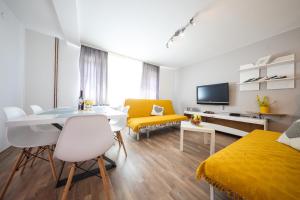 a living room with a table and a yellow bed at ANAI Serenity apartment , private heated pool and Hot Tub in Sukošan