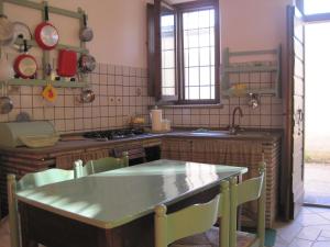 a kitchen with a sink and a table with chairs at Agriturismo l'Oasi in Foligno