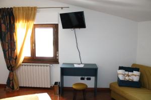 een woonkamer met een tafel en een tv aan de muur bij B&B La Casa di Sirio in Norcia