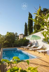 einen Pool mit Liegestühlen und einem Sonnenschirm in der Unterkunft Mondinica Heritage House in Dobrinj