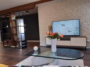 una sala de estar con un jarrón de flores sobre una mesa de cristal en Rome Apartment en Rheineck