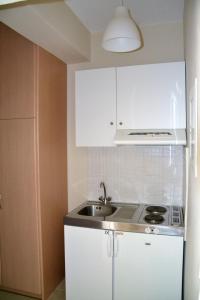 a kitchen with white cabinets and a sink at Villa Gianna in Apolpaina