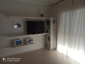 a living room with a flat screen tv and a window at El Rincón de Umbria in Punta Umbría