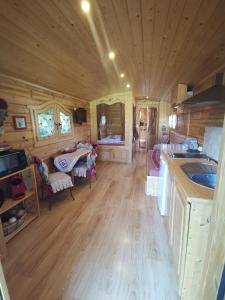 a kitchen and living room of a log cabin at Roulotte du Soleil in Eyragues