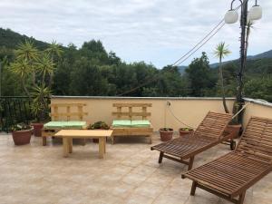 un patio con panche e tavoli su un balcone di Villa alle Marixe ad Albenga