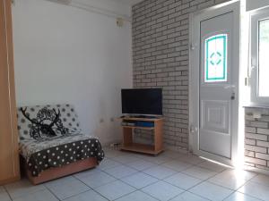 een woonkamer met een stoel en een televisie bij Sea view Holiday Home in Okrug Gornji near Bocici Beach in Trogir
