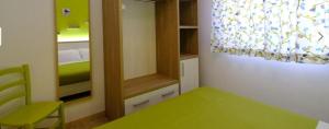 マッティナータにあるARBI case vacanzeのベッド付きの部屋、緑のテーブル付きのベッドルームが備わります。