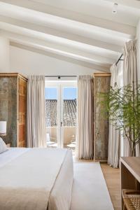 a bedroom with a large bed and a large window at Hotel Bodega Tio Pepe in Jerez de la Frontera